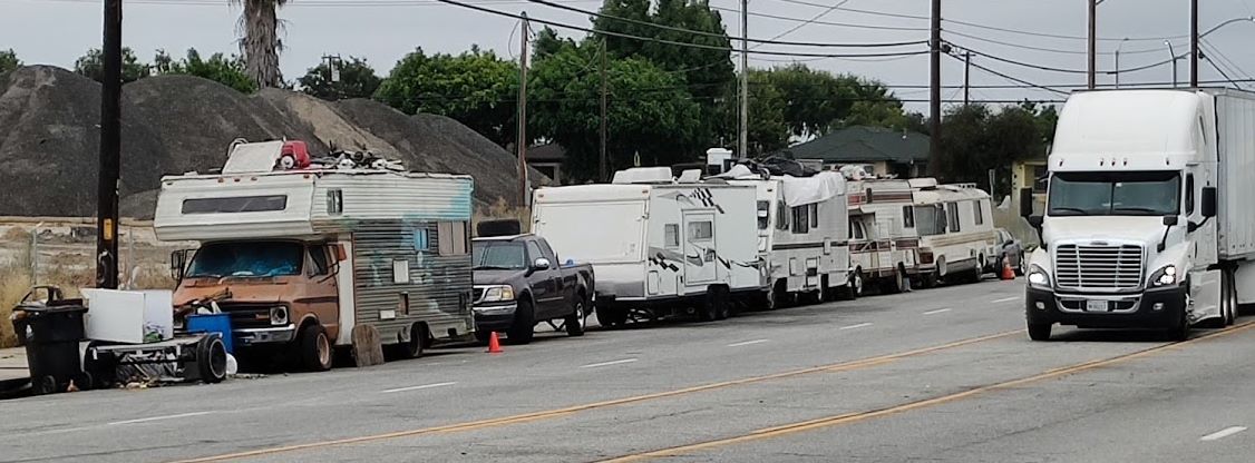 Campers near warehouse with a big rig